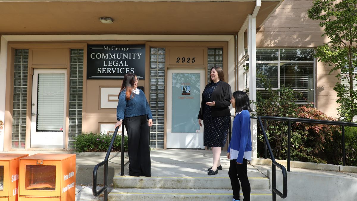 Three women speak to each other outside of the clinics building
